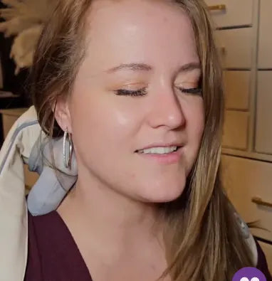 Woman using the TheraPexa neck and shoulder massager at home, smiling with eyes closed while enjoying hands-free deep tissue relief.