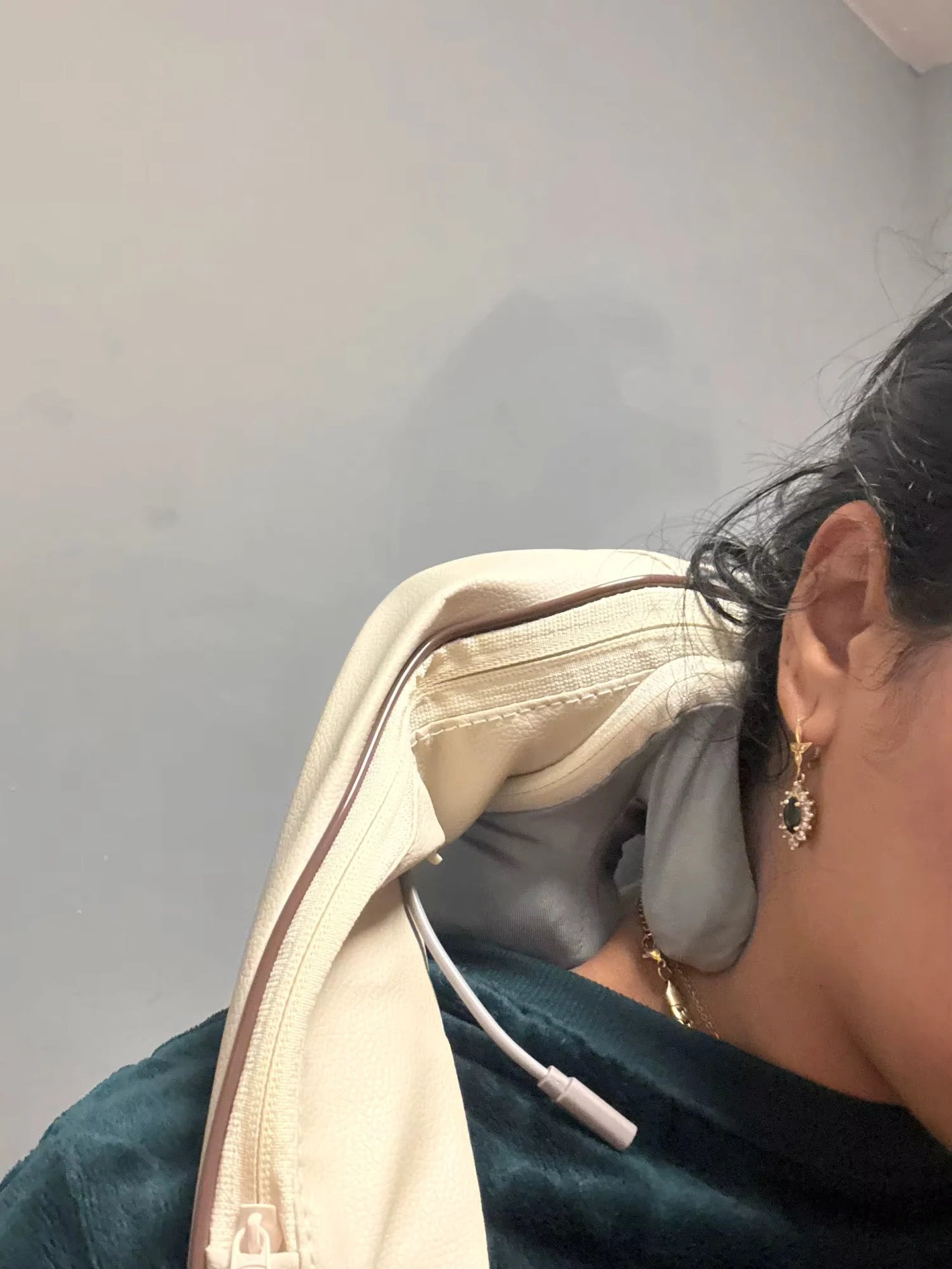 Close-up of woman using TheraPexa neck and shoulder massager, showing soft fabric texture and ergonomic design on the neck.